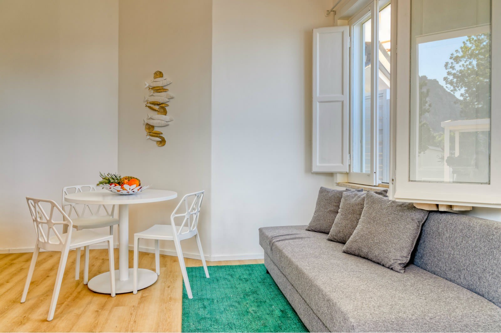 Arredamento zona giorno, divano, tavolo e sedie, veduta mare. Progetto di interior design CMC La Torre
